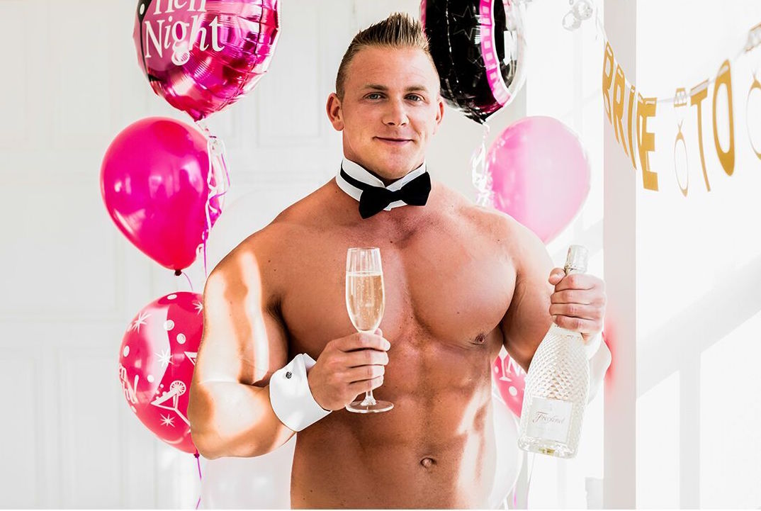 A buff butler holding a bottle of presecco