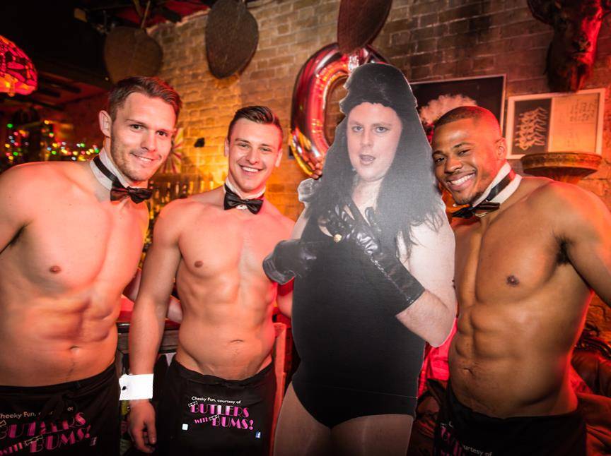 Butlers stood with a cutout of someone in black