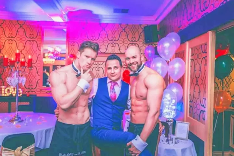 Butlers in the Buff hosts posing with guests at an LGBTQ+ celebration