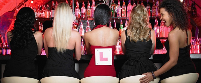 Woman in red with a learning symbol on her back sat with other women wearing black