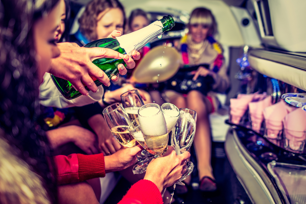 Girls wearing hen party accessories in a party bus